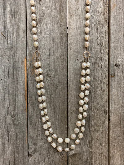 J.Forks Designs necklace on wooden backdrop. This is a 34" two strand freshwater pearl and bronze necklace with a bronze hook clasp.